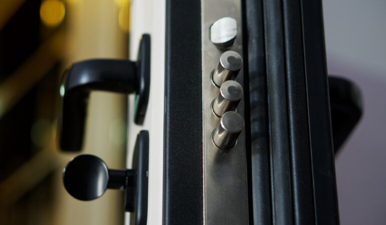 Door lock bolts on an open armored entrance door. Locking mechanism on a door lock. Rubber tubular seals for door sealing. Apartment and house protection. Photo. Selective focus. Close-up